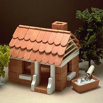 Steinbaukasten Einfamilienhaus Häuser bauen mit Mörtel und Maurerkelle.